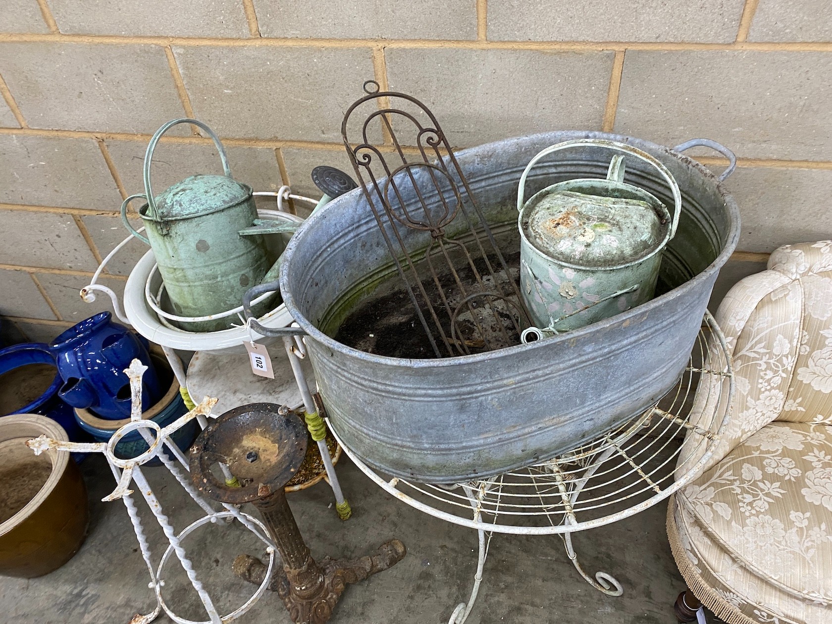 An oval galvanised water trough, a wrought iron washstand, garden table and sundry metalware